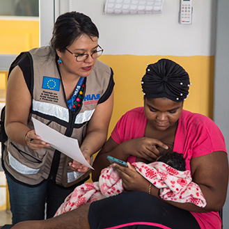 An HIAS worker helping a mother and her child. Links to Gifts That Pay You Income